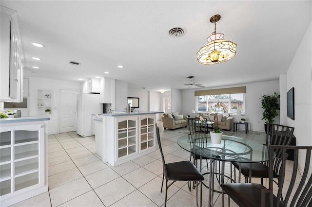 tiled dining space with built in shelves and ceiling fan