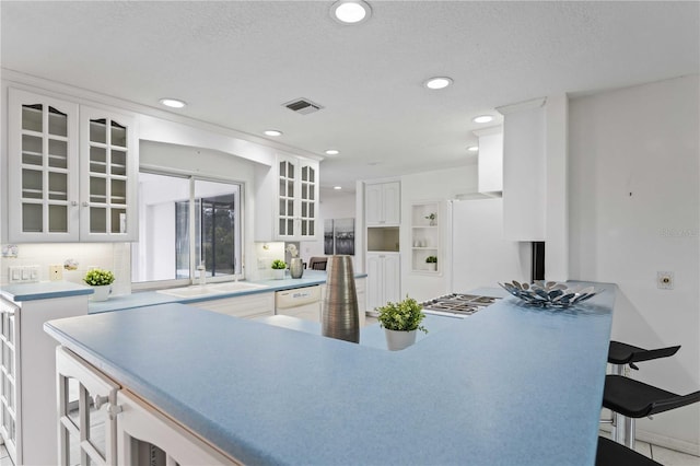 kitchen with white cabinetry, white appliances, and a kitchen breakfast bar