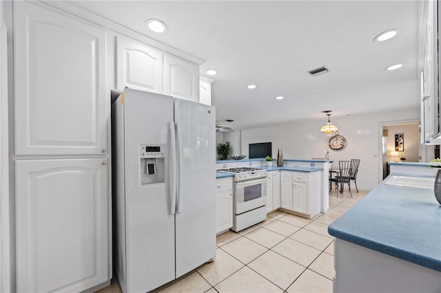 kitchen featuring light tile patterned floors, white appliances, kitchen peninsula, and white cabinets