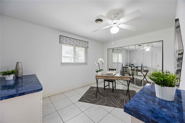 tiled office space featuring ceiling fan and a healthy amount of sunlight