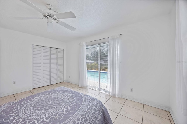 tiled bedroom with ceiling fan, access to exterior, a closet, and a textured ceiling