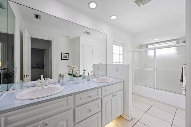 bathroom featuring vanity, bath / shower combo with glass door, and tile patterned flooring