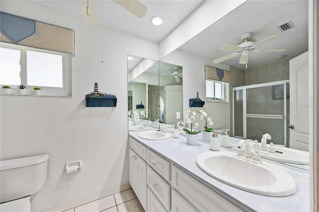 bathroom with a shower with door, a healthy amount of sunlight, tile patterned floors, and ceiling fan