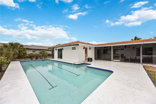 view of swimming pool featuring a patio, a sunroom, and ceiling fan