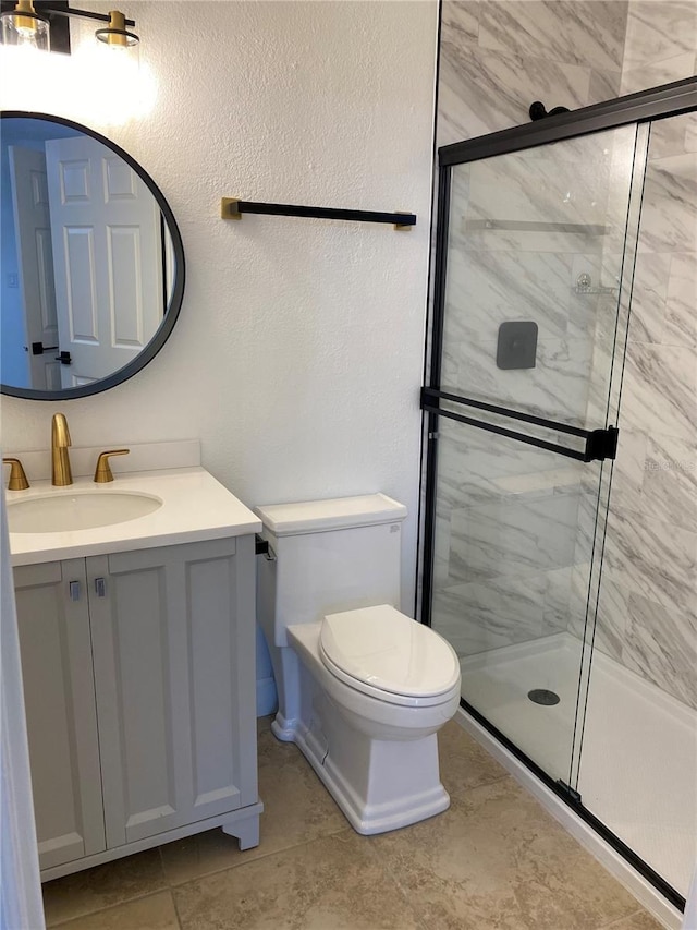 bathroom featuring vanity, an enclosed shower, and toilet