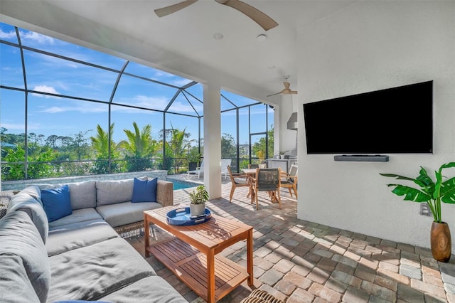 sunroom featuring an outdoor kitchen, ceiling fan, outdoor lounge area, and a patio