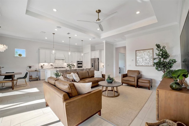 living room featuring ornamental molding, a raised ceiling, and ceiling fan