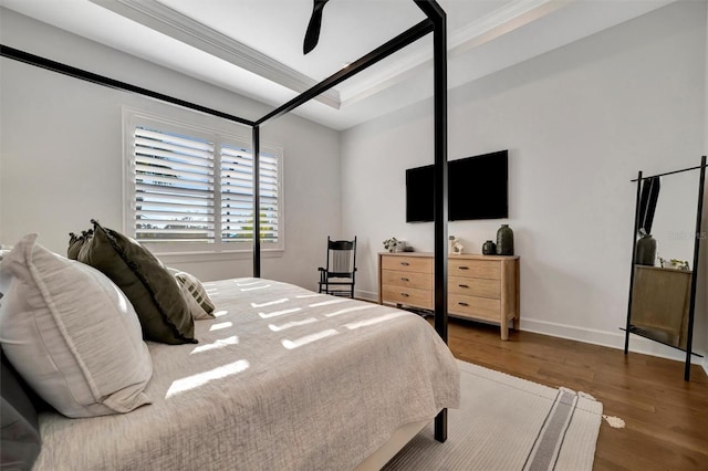 bedroom with crown molding, dark hardwood / wood-style floors, and ceiling fan