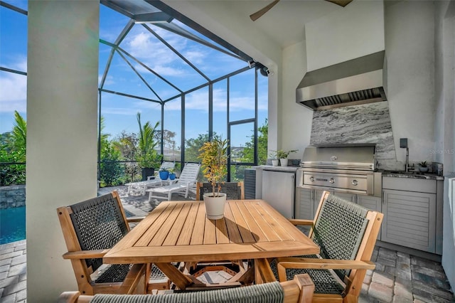 view of patio / terrace featuring ceiling fan, an outdoor kitchen, a grill, and glass enclosure