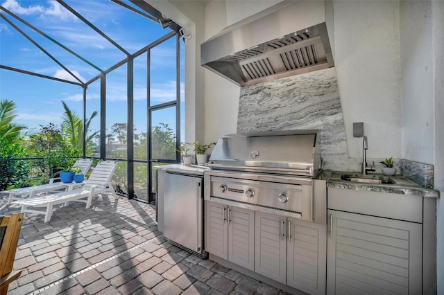 view of patio / terrace with sink, a grill, glass enclosure, and exterior kitchen