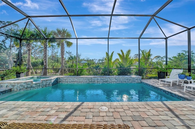 view of pool with an in ground hot tub, a patio area, and glass enclosure