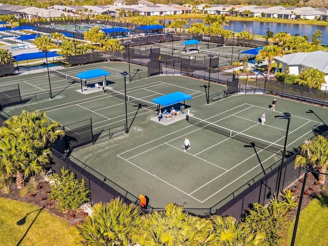 view of tennis court with a water view