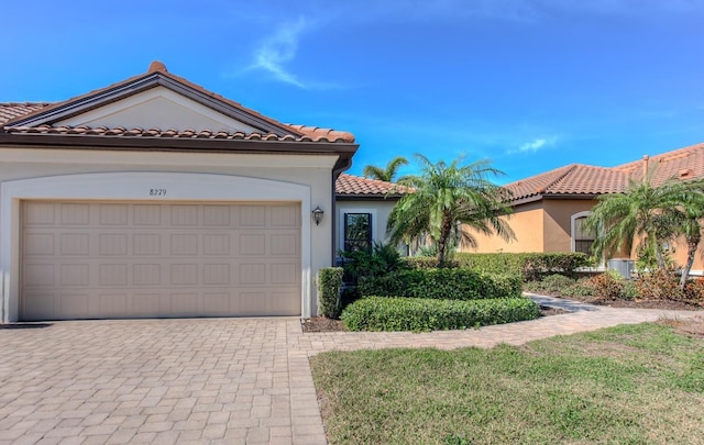 mediterranean / spanish-style house with a garage and a front yard