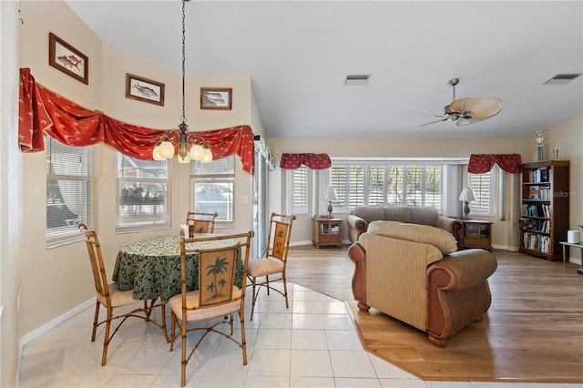 dining room with ceiling fan with notable chandelier and light hardwood / wood-style floors