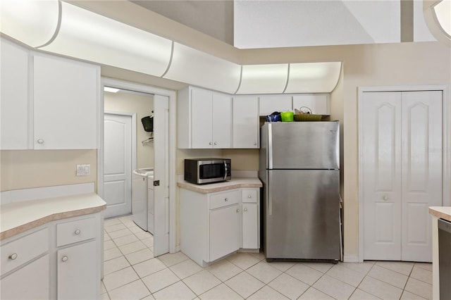 kitchen with washing machine and dryer, white cabinets, and appliances with stainless steel finishes