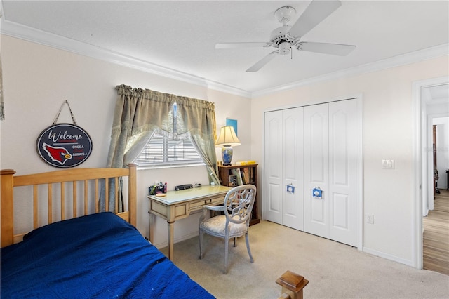 bedroom featuring ornamental molding, light colored carpet, a closet, and ceiling fan