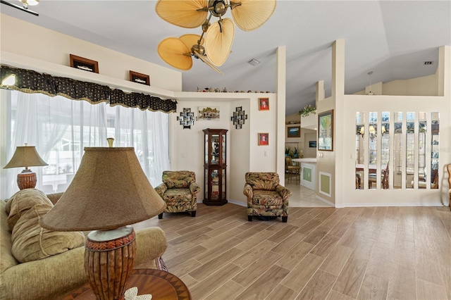 living room featuring ceiling fan, a wealth of natural light, and light wood-type flooring