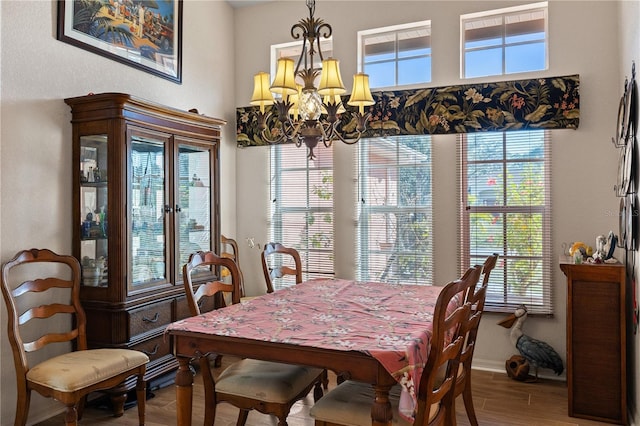 dining space featuring hardwood / wood-style flooring, a wealth of natural light, and an inviting chandelier