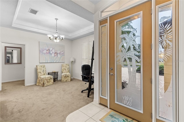 entryway featuring light carpet, a chandelier, and a tray ceiling