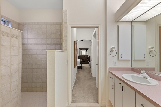 bathroom featuring a tile shower and vanity