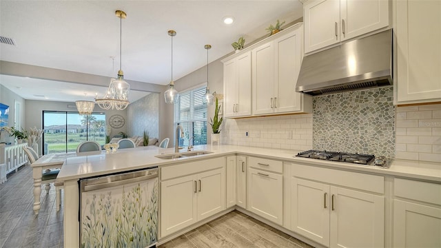 kitchen featuring dishwasher, sink, decorative backsplash, hanging light fixtures, and kitchen peninsula