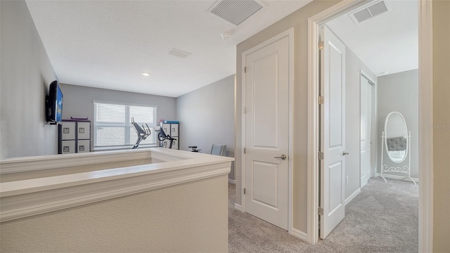 hall featuring light colored carpet