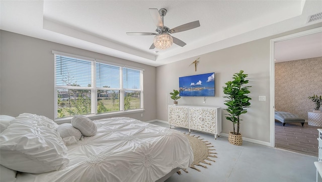 bedroom with a tray ceiling and ceiling fan