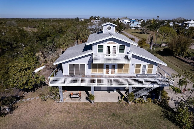 rear view of property featuring a lawn, a patio area, and french doors