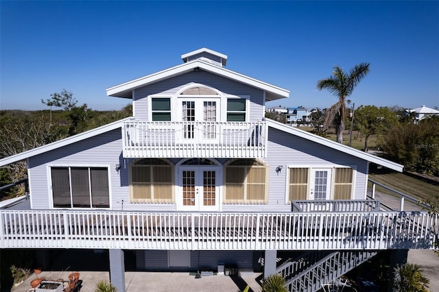 rear view of house with french doors and a balcony