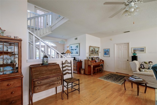 interior space featuring ceiling fan, a textured ceiling, and light wood-type flooring