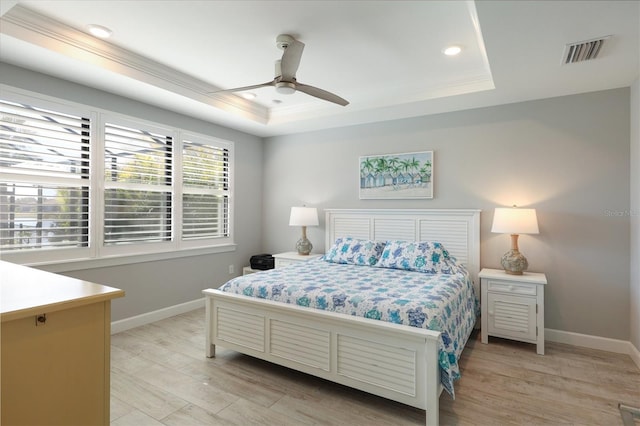 bedroom featuring crown molding, ceiling fan, a raised ceiling, and light hardwood / wood-style floors