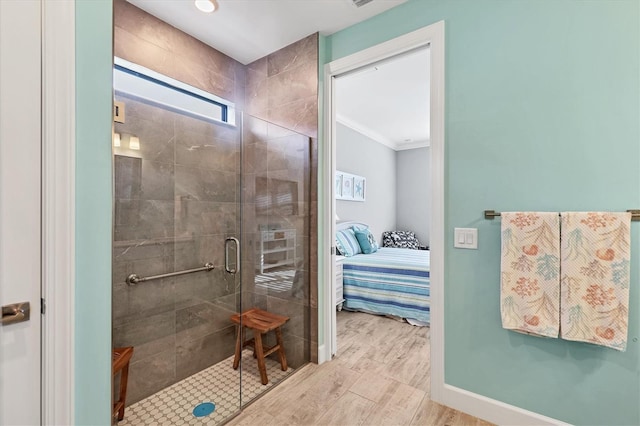 bathroom featuring crown molding, a shower with door, and hardwood / wood-style flooring