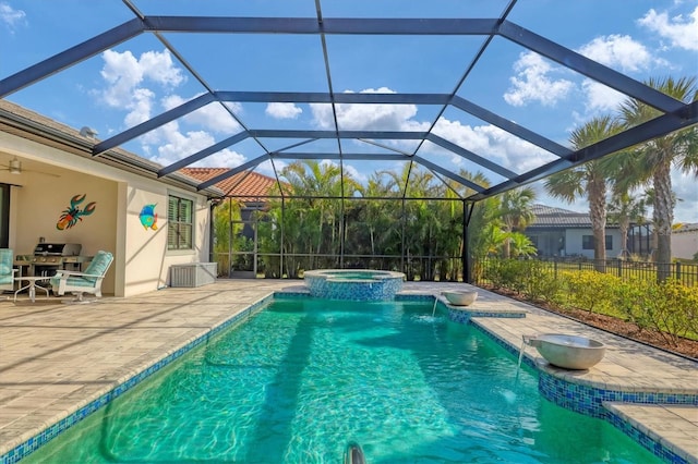 view of swimming pool featuring pool water feature, a patio area, a lanai, an in ground hot tub, and ceiling fan