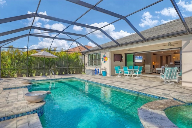 view of swimming pool featuring a patio area, ceiling fan, and glass enclosure