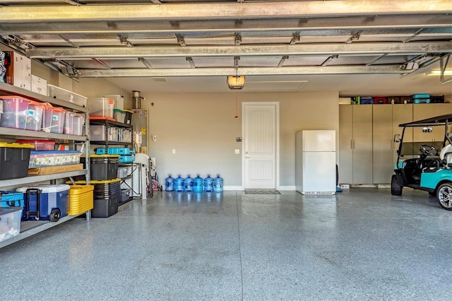 garage featuring a garage door opener, water heater, and white refrigerator