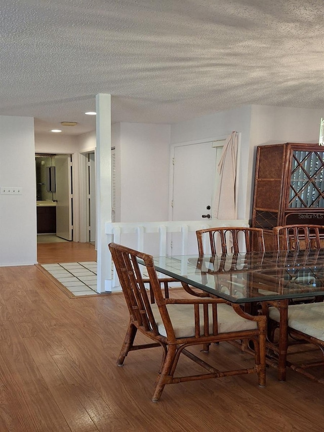 dining room with a textured ceiling and light wood-type flooring