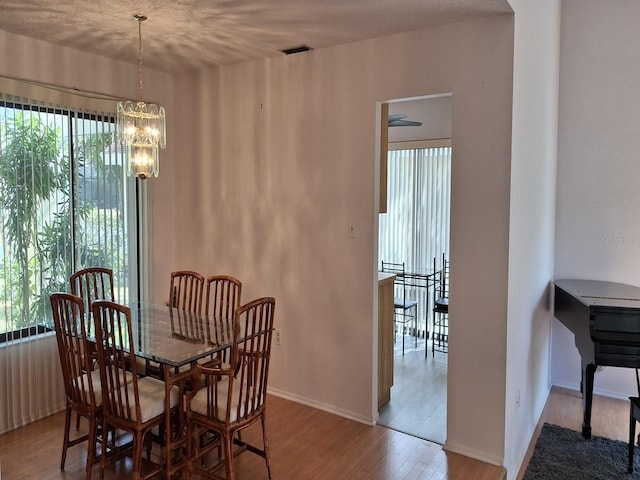 dining area with hardwood / wood-style flooring and a notable chandelier