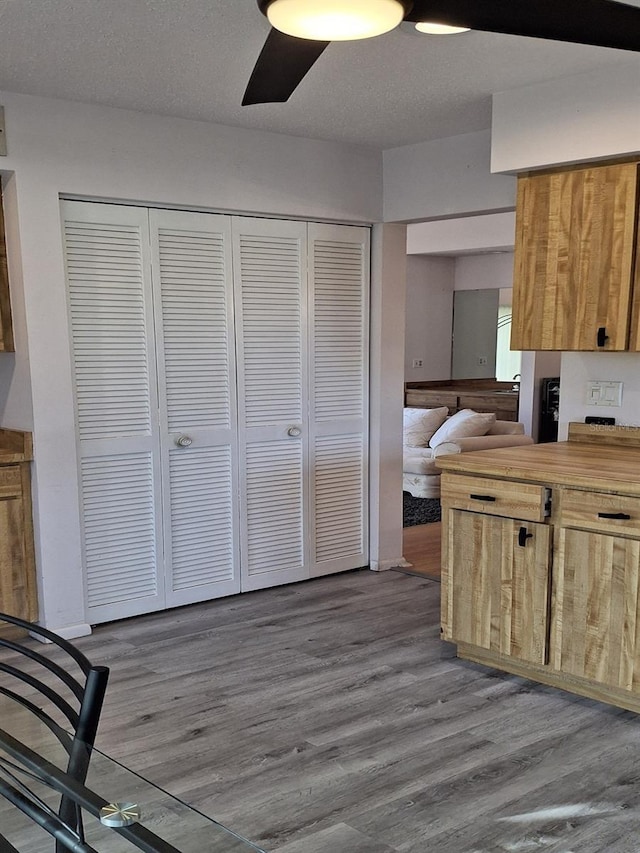 kitchen featuring ceiling fan, hardwood / wood-style floors, and a textured ceiling