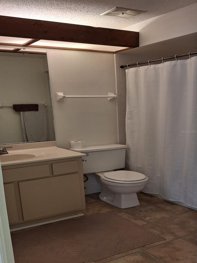 bathroom with vanity, toilet, and a textured ceiling