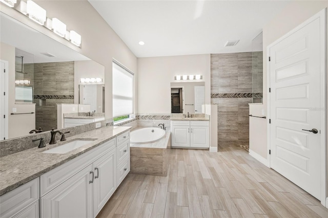 bathroom with vanity and separate shower and tub