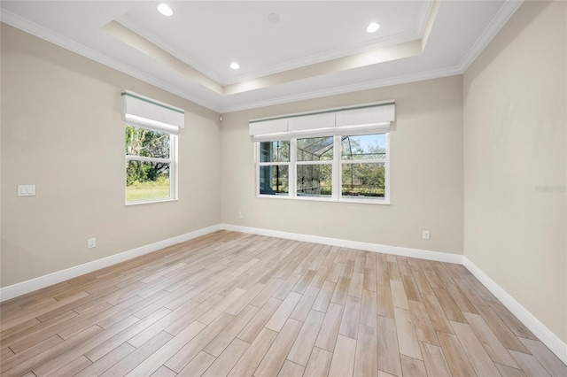 unfurnished room featuring ornamental molding, a raised ceiling, and light hardwood / wood-style floors