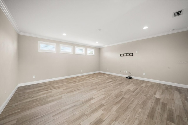 spare room with ornamental molding and light hardwood / wood-style flooring