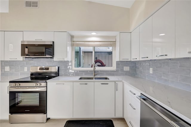 kitchen featuring stainless steel appliances, tasteful backsplash, sink, and white cabinets