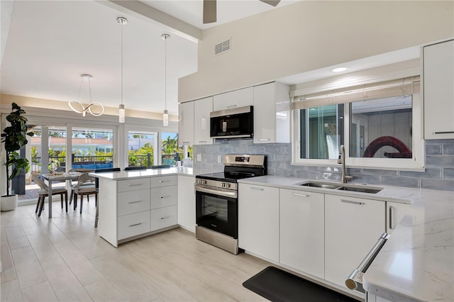 kitchen with white cabinetry, sink, backsplash, hanging light fixtures, and stainless steel electric range