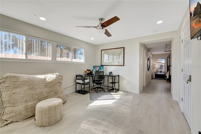 home office with ceiling fan and light hardwood / wood-style flooring