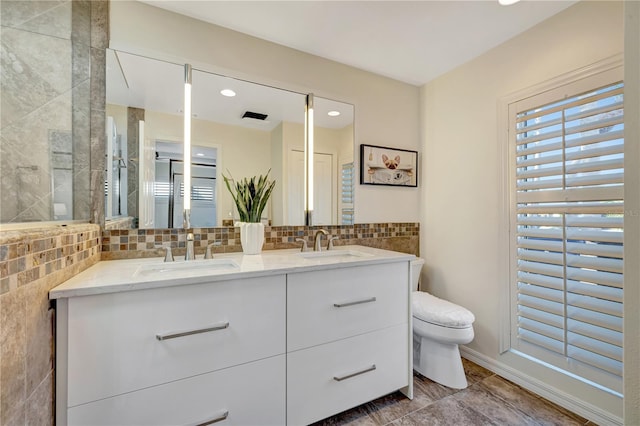 bathroom with vanity, toilet, and backsplash