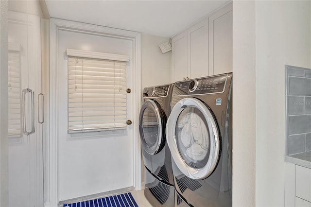 clothes washing area with cabinets and independent washer and dryer