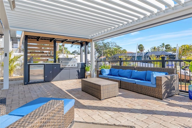 view of patio with a grill, a pergola, an outdoor hangout area, and exterior kitchen