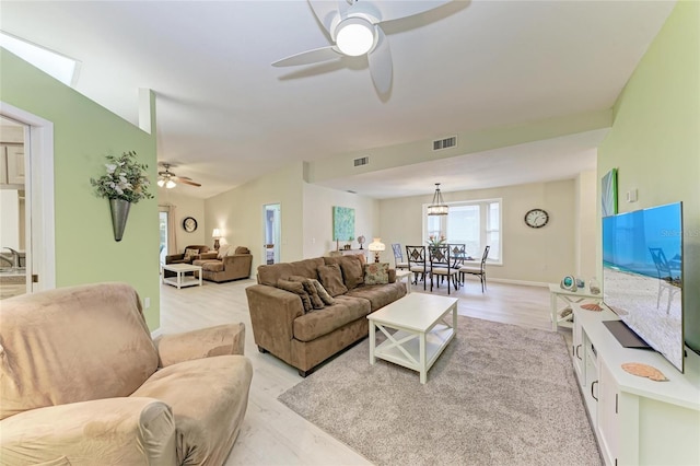 living room featuring lofted ceiling, light hardwood / wood-style floors, and ceiling fan