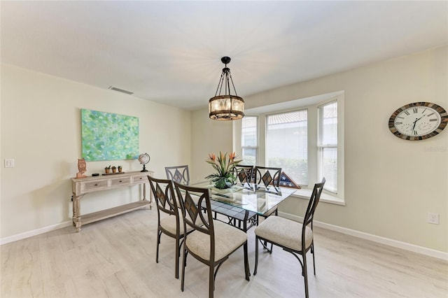 dining room featuring an inviting chandelier and light hardwood / wood-style flooring